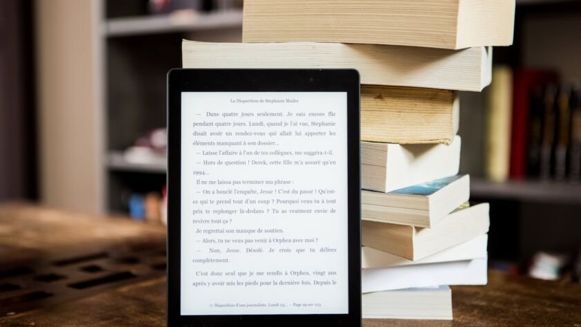 black tablet computer behind books